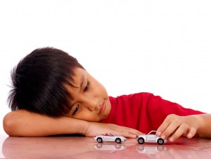 Young Boy On His Own Playing With His Cars